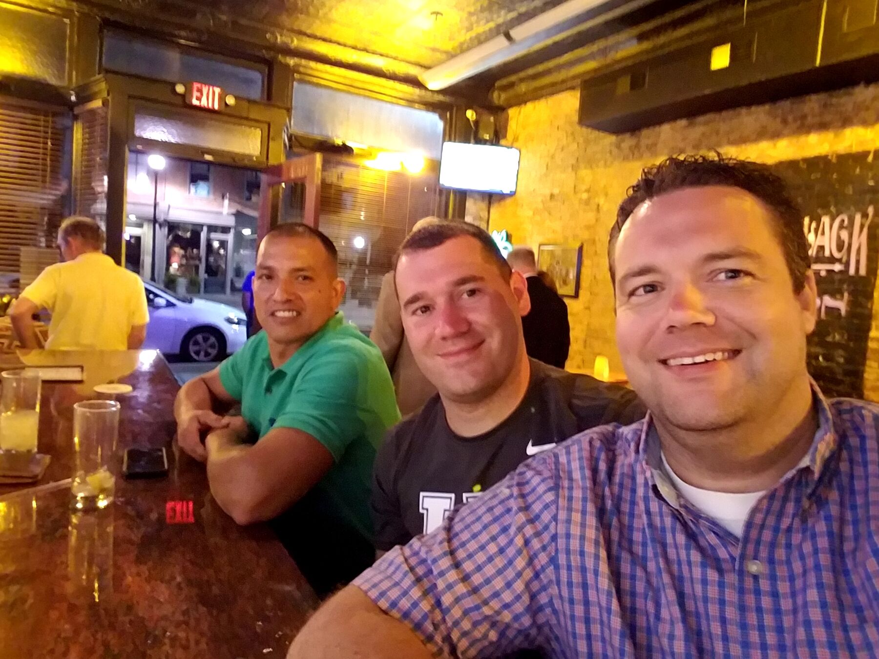 Justin and two friends at a bar