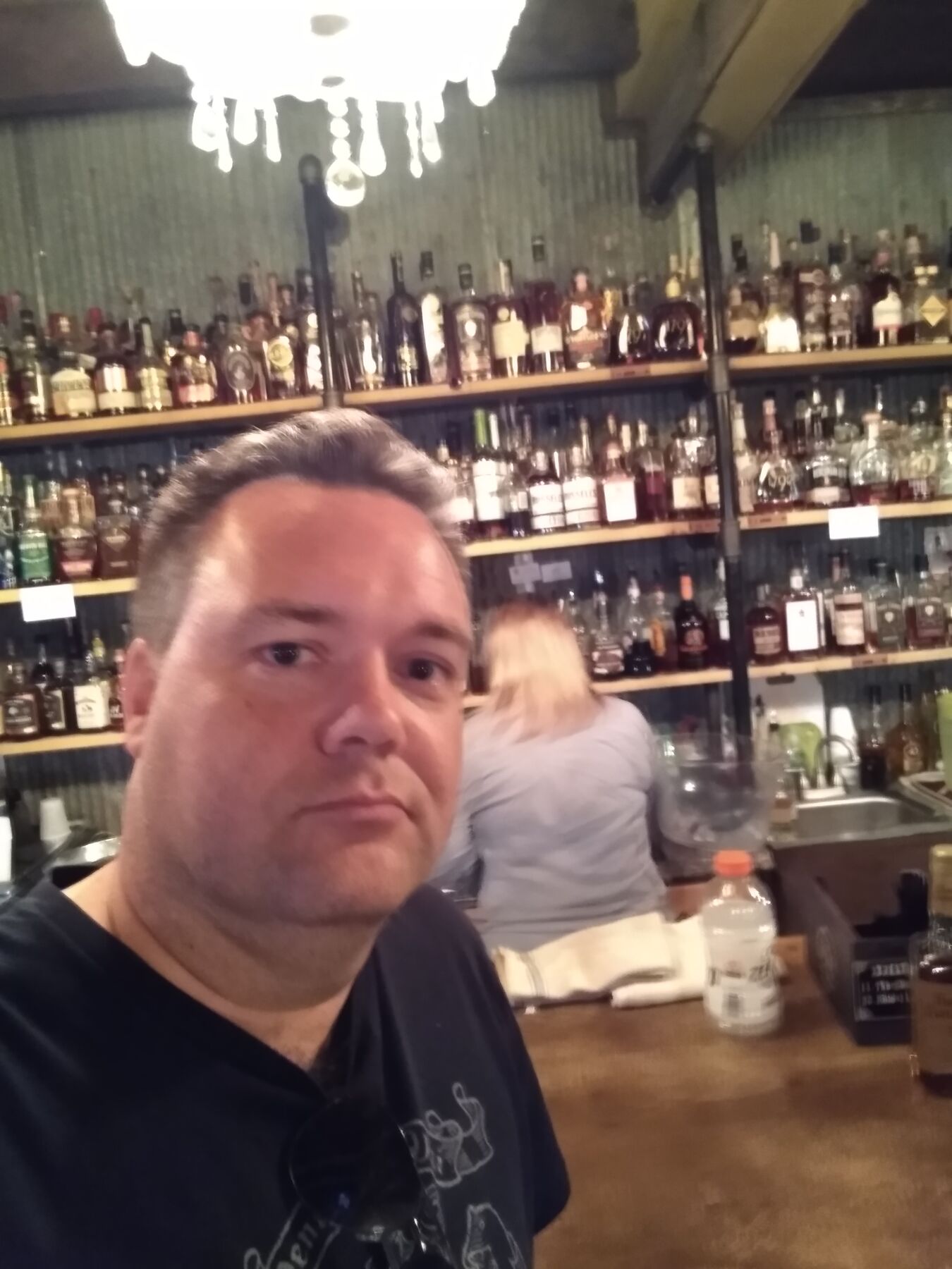Justin in front of a wall of bourbon