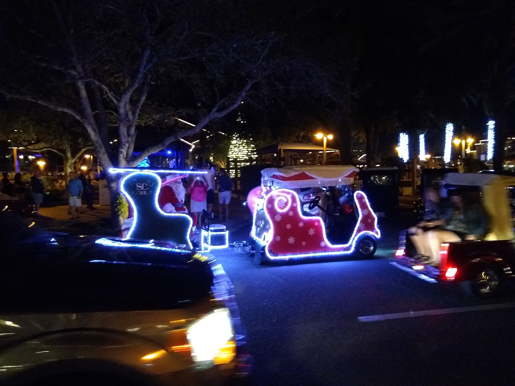 Golf carts lit up as sleighs