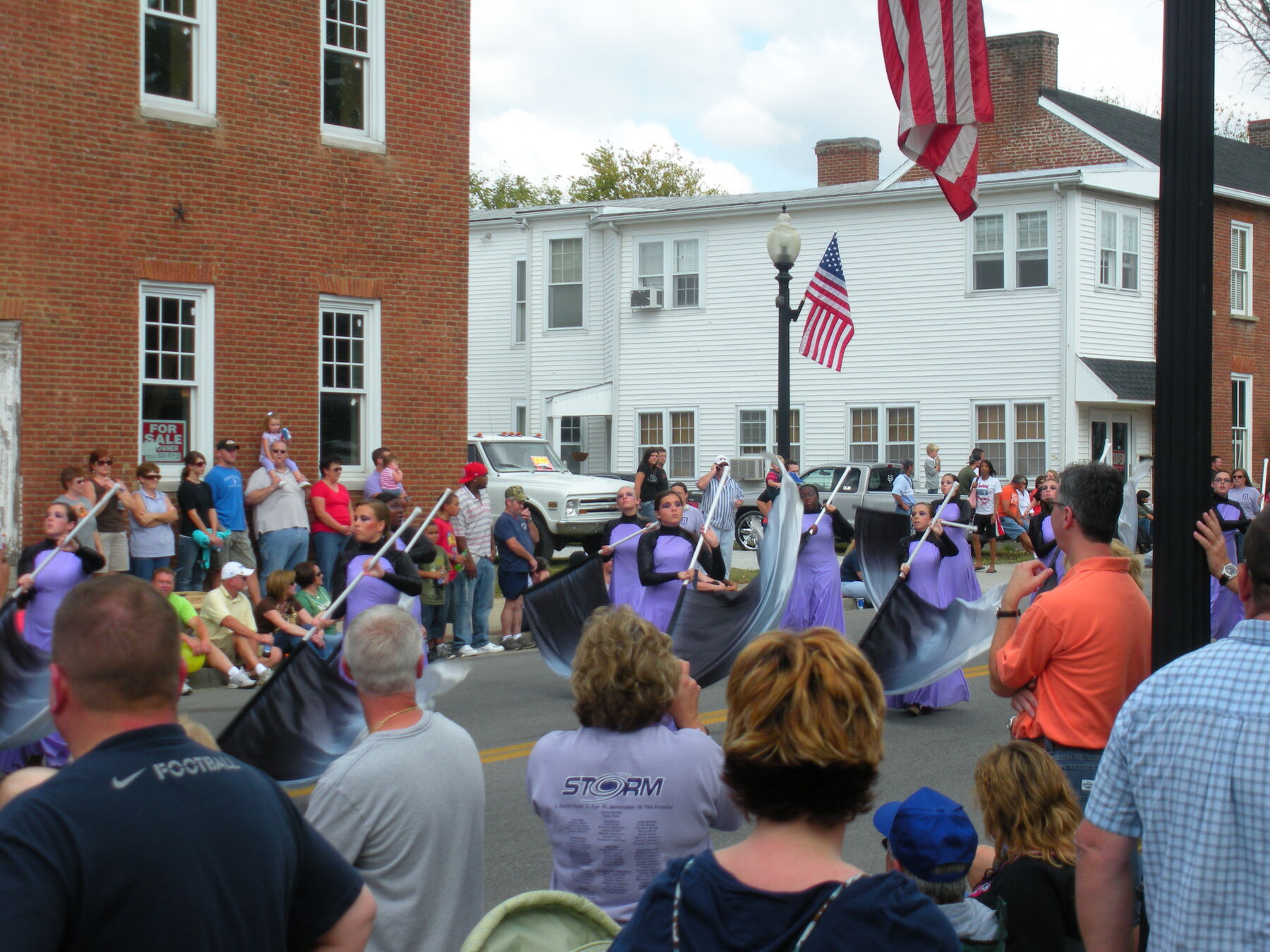 A small-town parade under flags