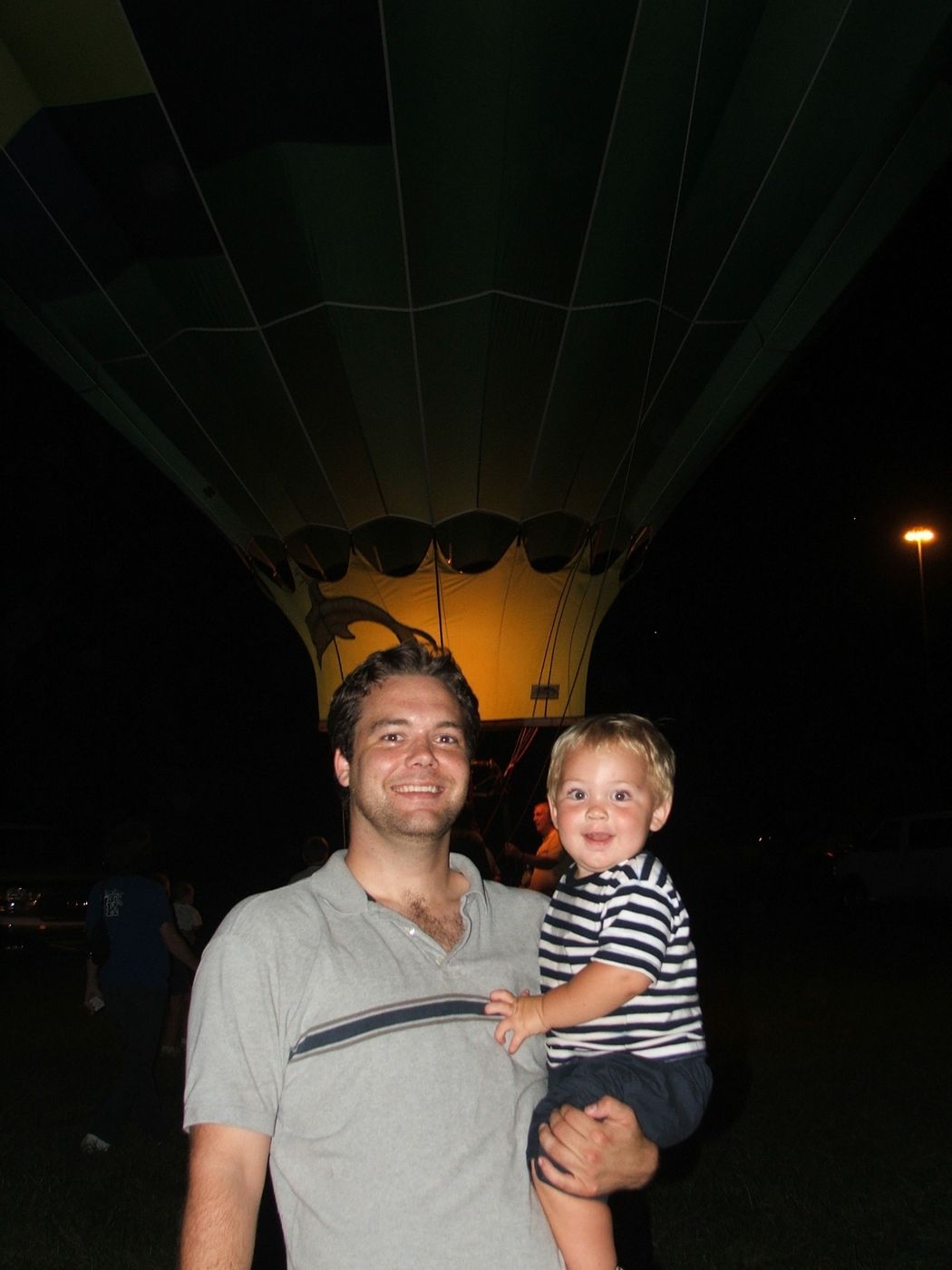 Justin and a little one in front of a glowing hot air balloon