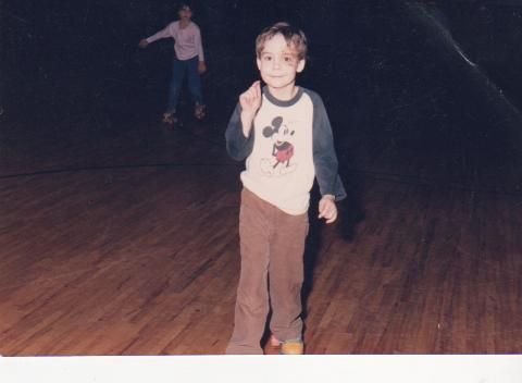 A kid on a roller rink floor, years ago