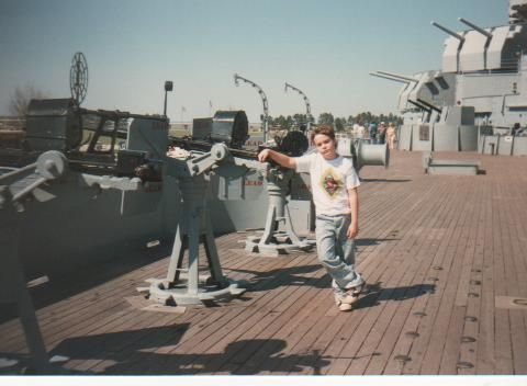 A kid on the deck of a battleship, years ago