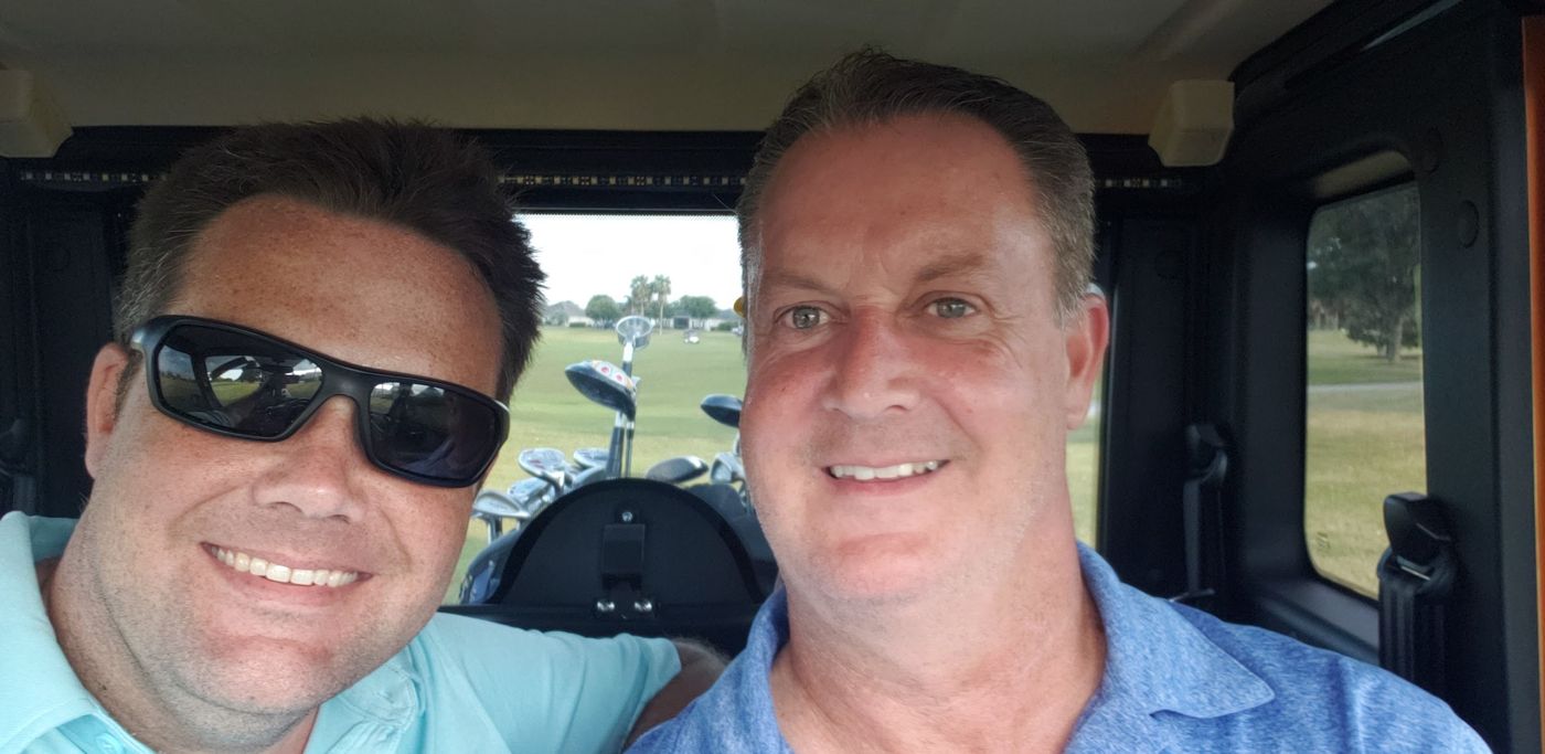 Justin and a friend in a golf cart