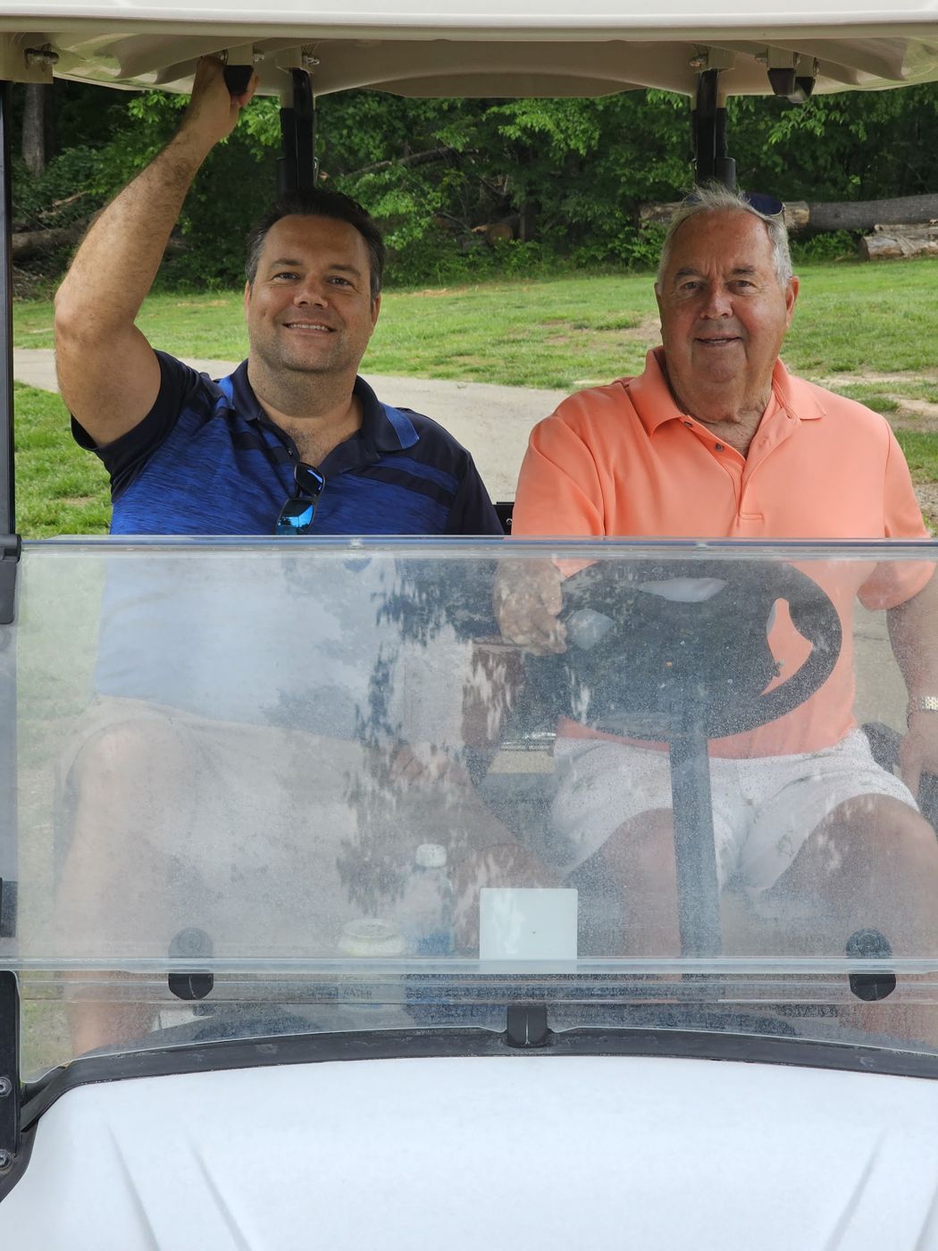 Justin and a friend in a golf cart
