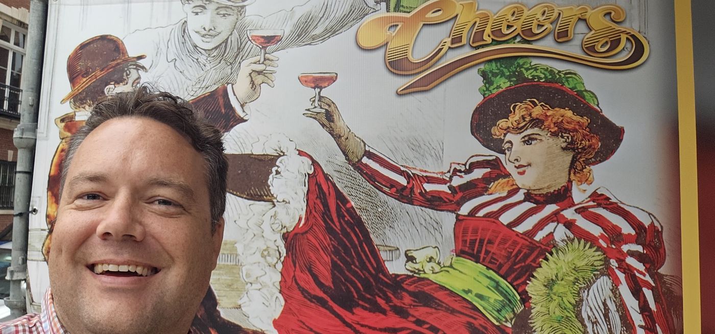 Justin in front of a Cheers mural