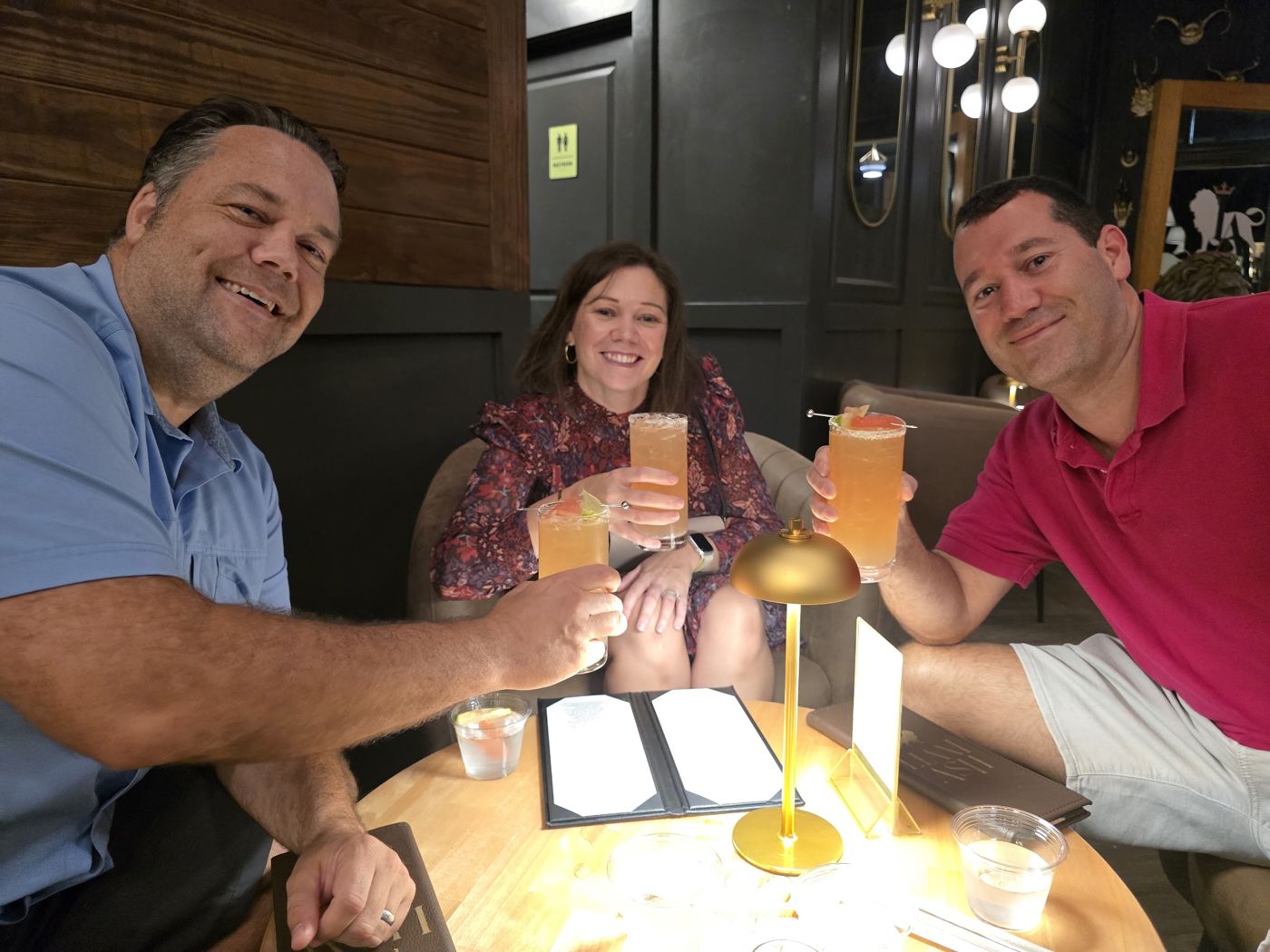 Three friends toasting at dinner