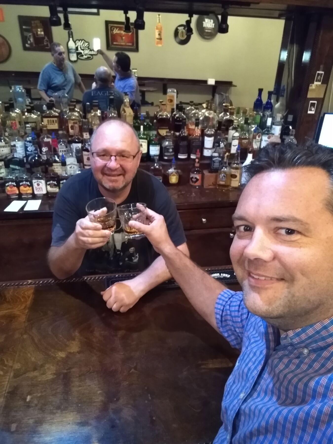 Justin and a friend toasting at a bourbon bar